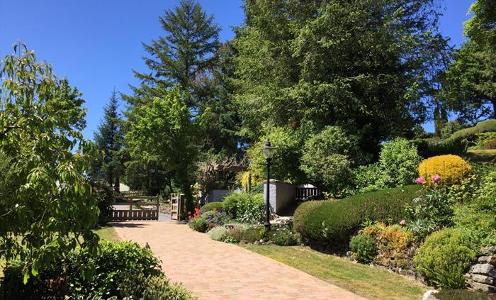 View from the garden room across the gardens, wonderful shrubs and manicured lawns.